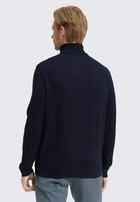 Marineblauer Strickpullover mit hohem Kragen, langen Ärmeln, gerippten Bündchen und Saum, minimalistischem Design und glatter Textur.