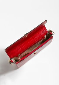 Bolso de mano rojo con patrón de cocodrilo, con un exterior de cuero texturizado, herrajes dorados y un interior espacioso que incluye un bolsillo con cremallera.