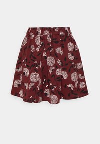 Jupe bordeaux avec un motif floral en blanc et noir. Ceinture élastique avec plis, texture de tissu lisse.