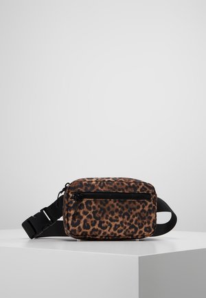Kompakti leopardi-kuosinen vyölaukku, jossa musta säädettävä hihna ja etutasku vetoketjulla, valkoisella jalustalla vaaleanharmaata taustaa vasten.
