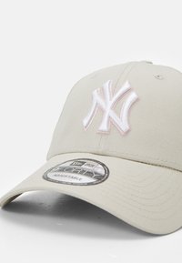 Beige verstellbare Mütze mit einem erhabenen weißen und rosafarbenen gestickten Logo der New York Yankees, mit einem strukturierten Schirm und strukturiertem Stoff.