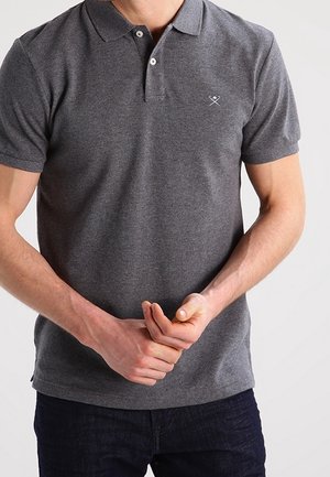 Polo gris à manches courtes en tissu de coton, doté d'un col classique, d'une patte à deux boutons et d'un petit logo brodé sur la poitrine.