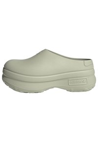 Ljust grå Adidas-klumpar i ett slätt gummimaterial, rundad form och en tjock, strukturerad sula. Logotyp synlig på sidan.