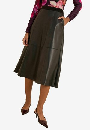 Musta nahkainen A-linjainen hame, jossa on sileä pinta, vyötärö ja näkyvä sivutasku. Mallilla on päällään burgundin väriset slingback-korkokengät.