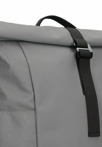 Zaino grigio a chiusura roll-top realizzato in tessuto testurizzato con un motivo geometrico. Presenta una tracolla nera e una fibbia per una chiusura sicura.