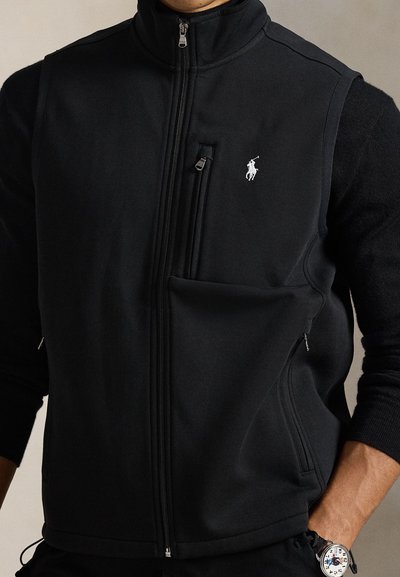 Μαύρο γιλέκο με φερμουάρ και ψηλό γιακά, με μπροστινή τσέπη και λογότυπο. Μαλακό ύφασμα με ομαλή υφή και δομημένο σχέδιο.