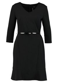 Svart knälång klänning med V-ringning, trekvartsärmar och fladdrande nederkant, accentuerad med ett tunt svart bälte med en glänsande spänne.
