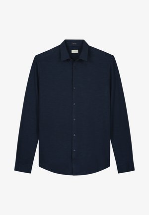 Tume mereva kootedega särk, millel on tekstuuriga kangas. Omab nööpidega kaelust, nööbipluusi esiosa ja delikaatset logosümbolit rinnal.