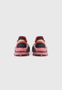 Μαύρα και κόκκινα αθλητικά παπούτσια με υφασμένο επάνω μέρος, πολύχρωμες λεπτομέρειες και παχύ, σχέδιο σόλας με μαρμάρινη υφή.