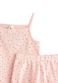 Vaaleanpunainen puuvillapuku, jossa on hihaton toppi kapeilla olkaimilla ja sopiva kuminauhahelma, molemmat koristeltu pienillä vaaleanpunaisilla sydänkuvioilla.