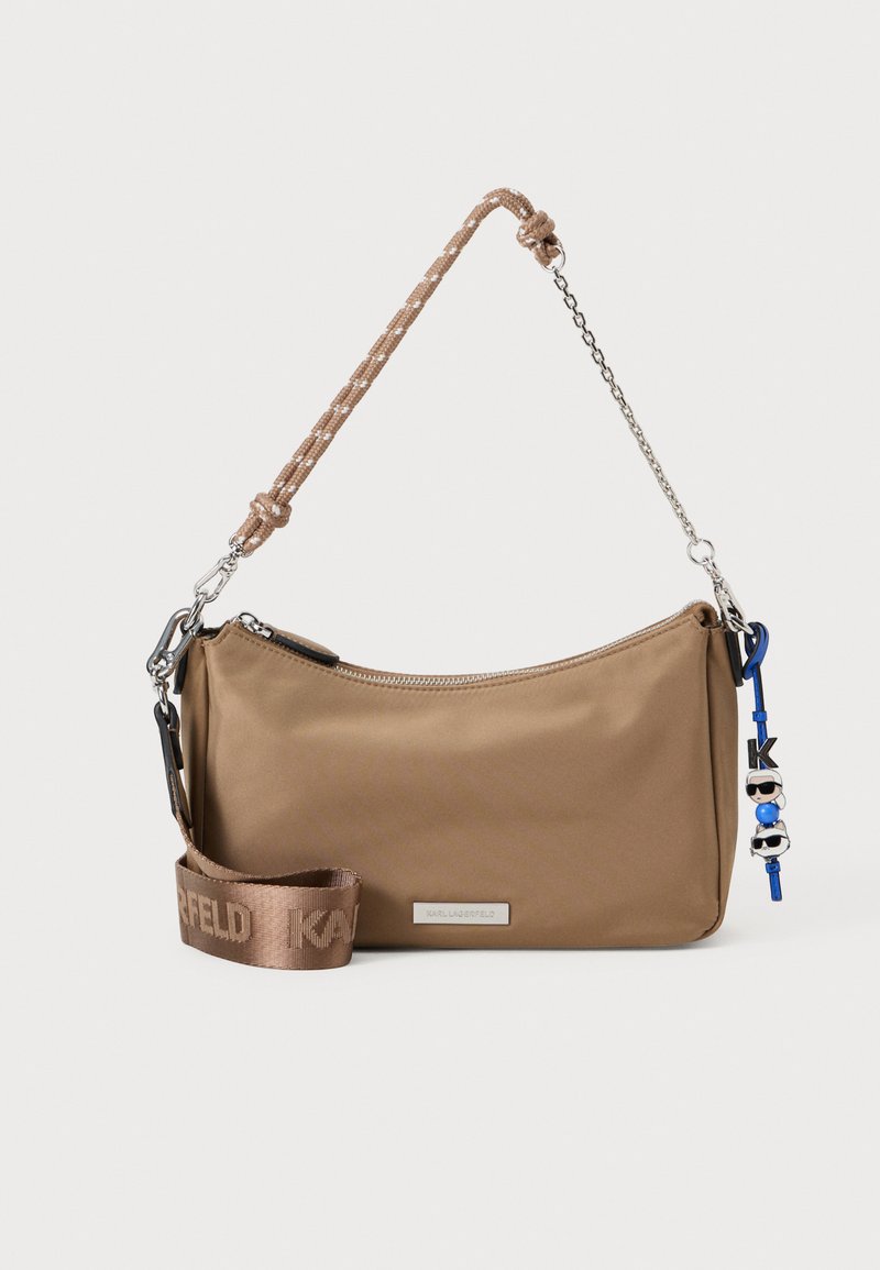 Saco de ombro em nylon castanho com uma alça trançada, um pega de corrente, hardware prateado, fecho de correr e um charm com figuras de cartoons.