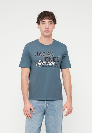 Blaues Baumwoll-T-Shirt mit kurzen Ärmeln, versehen mit schwarzem und weißem grafischem Text, der "JACK & JONES Superior New Aesthetics" lautet.