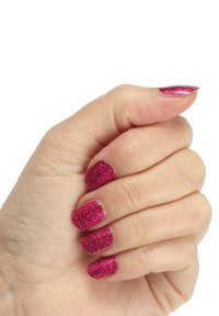 Sprankelende roze glitters in nagellak op korte, vierkante nagels. Hand is voor een deel gebald, waardoor de levendige kleur en textuur zichtbaar zijn.