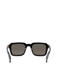 Lunettes de soleil rectangulaires noires avec des montures épaisses et des verres teintés foncés, vues de face avec des branches légèrement inclinées.