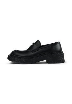 Schwarze Lederloafer mit runder Zehenpartie, ausgeprägten Nähten und einer dicken, strukturierten schwarzen Plateausohle. Glatte Oberfläche mit minimalistischem Design.