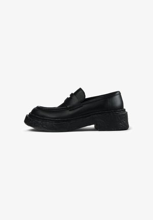 Schwarze Lederloafer mit runder Zehenpartie, ausgeprägten Nähten und einer dicken, strukturierten schwarzen Plateausohle. Glatte Oberfläche mit minimalistischem Design.