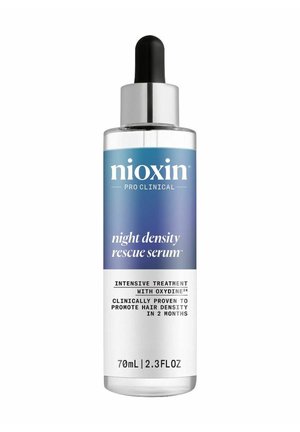 Transparante glazen fles met een zilveren druppelaar-cap. Blauw-wit etiket met de tekst "Nioxin Pro Clinical Night Density Rescue Serum," 70 ml.