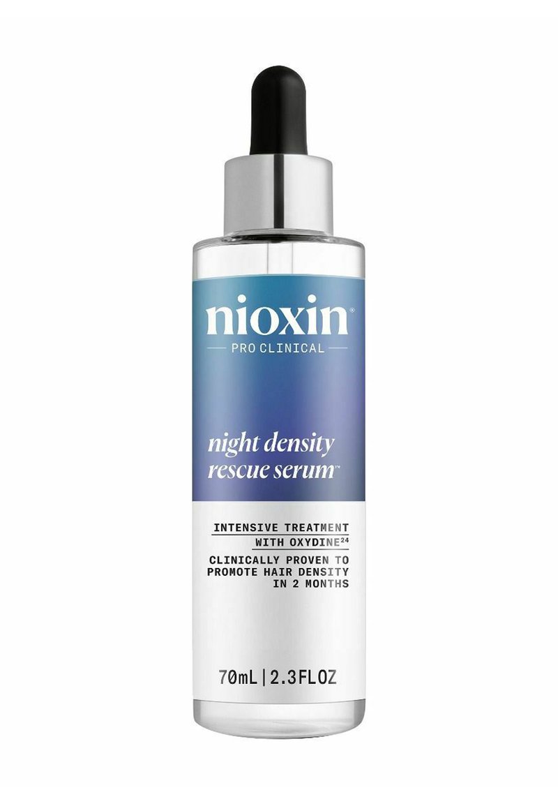 Transparante glazen fles met een zilveren druppelaar-cap. Blauw-wit etiket met de tekst "Nioxin Pro Clinical Night Density Rescue Serum," 70 ml.
