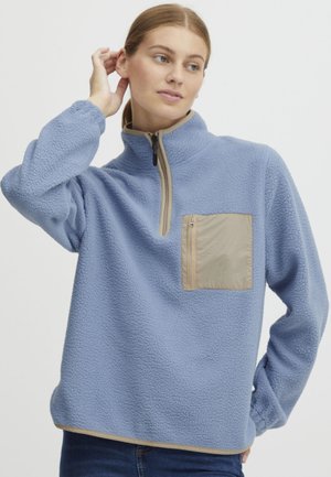 Pullover in felpa blu con collo a quarto di zip, tasca sul petto con zip beige e orlo a contrasto. Tessuto strutturato con maniche lunghe.