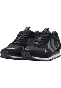 Schwarze sportliche Sneakers aus einer Mischung aus Wildleder und Mesh-Materialien, mit strukturiertem Obermaterial, grauen Akzenten und hellfarbiger Sohle.