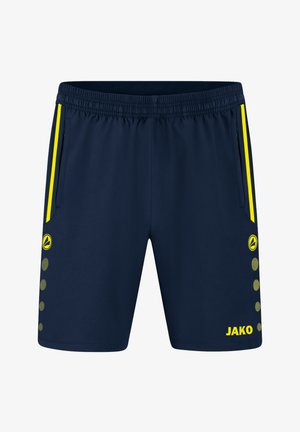 Pantaloni sportivi blu navy con cintura elastica, tasche laterali, accenti gialli e motivo circolare vicino all'orlo. Marchio "JAKO" in giallo.
