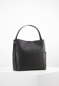 Sort håndtaske med et tekstureret slangeskinsmønster, glatte læderdetaljer og en åben top. To sidelommer øger funktionaliteten.