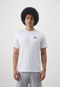 Wit sport t-shirt met korte mouwen en een ronde hals, voorzien van een klein zwart Adidas-logo op de linkerborst, gemaakt van gladde stof.