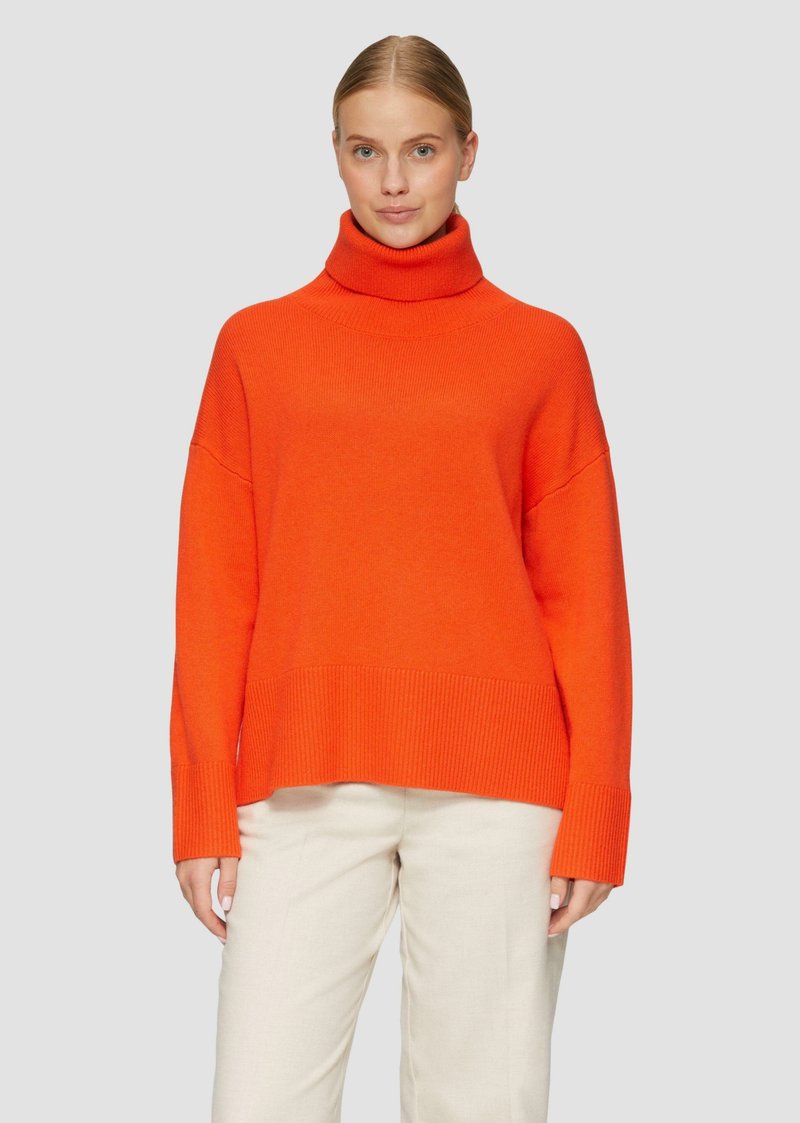 Hellig orange Rollkragenpullover mit lockerem Schnitt, gerippten Bündchen und Saum. Der Stoff scheint weich zu sein, mit einer glatten Textur und ohne sichtbare Muster.