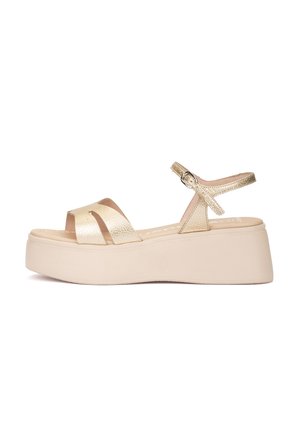 Sandale à plateforme beige avec des brides texturées dorées métalliques et une boucle à la cheville sur une semelle beige épaisse et solide.
