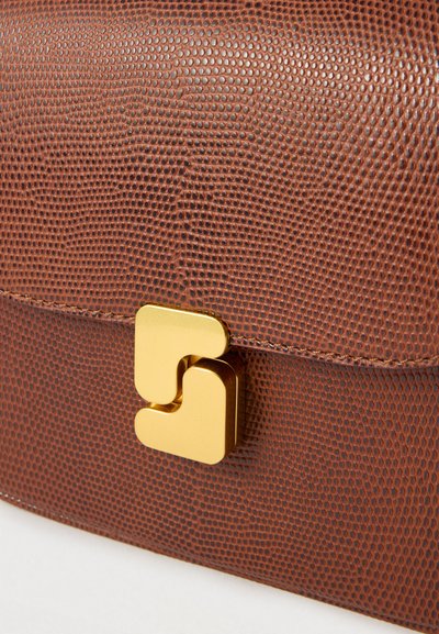 Καφέ τσάντα χειρός από δέρμα με υφή, διακοσμημένη με χρυσό τετράγωνο κούμπωμα, λείες άκρες και ομοιόμορφο σχέδιο με διακριτική γυαλάδα.