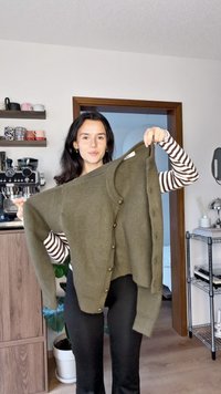 Olivově zelený pletený kardigan s kulatým výstřihem a velkými knoflíky, s žebrovanými manžetami a volným střihem. Strukturovaná, ale zároveň měkká textura.