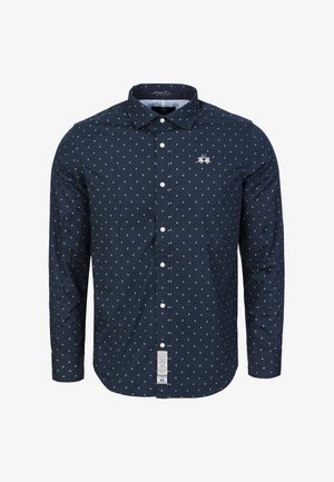 Granatowa koszula na guziki z małym, białym wzorem w kropki oraz logo na piersi. Posiada klasyczny kołnierz i długie rękawy. Teksturowana tkanina.