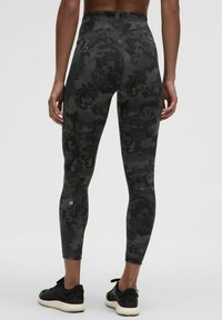 Leggings s visokim strukom u tamnom kamuflažnom uzorku, izrađene od elastične tkanine; prilagođen oblik, glatka tekstura, naglašene logotipom na članku.