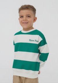 Felpa a righe verdi e bianche con "Have Fun" ricamato in verde. Presenta un collo tondo e maniche lunghe. Tessuto morbido e casual.