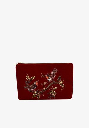 Červená sametová kabelka s vyšitými vtákmi sediacimi na konári so listami. Zipsové uzatváranie so zlatým kovovým prvkom. Hladká textura a obdĺžnikový tvar.