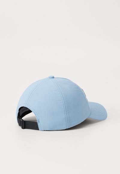 Casquette bleue claire avec un sommet arrondi, sangle noire ajustable, tissu texturé et bouton circulaire en haut. Design simple et sportif.