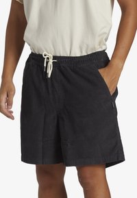 Sorte corduroy-shorts med elastisk talje og snor. Har sidelommer og en lige pasform, der slutter lige over knæet.