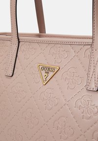 Borsa a tracolla sintetica rosa con motivo in rilievo, logo triangolare dorato, forma strutturata e doppi manici superiori accentuati da cuciture a contrasto.