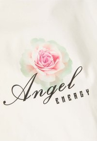 Witte stof met een roze rozenafbeelding en groene accenten boven de tekst "Angel ENERGY" in een mix van cursief en vetgedrukt zwarte letters.