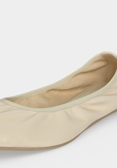 Μπεζ μαλακό δερμάτινο μπαλαρίνα με στρογγυλεμένη μύτη και χαμηλό τακούνι, με λείο εσωτερικό επένδυμα και ελαφρώς σούρες στη φάσα πάνω.