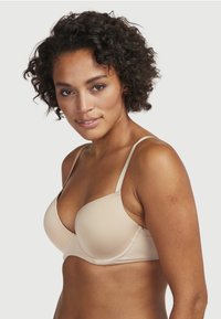 Nude balconette beha met gladde, lichtgevulde cups en verstelbare bandjes. Bevat een naadloos ontwerp en subtiele textuurstof.