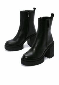 Black leather ankle boots with a smooth finish, chunky block heels, side zipper closure, and pull tab on the back for ease of wear.