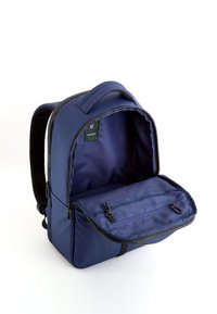 Marinblå ryggsäck med vadderade axelremmar, zippered fack och en slät yta. Insidan är klädd med ett texturerat mönster.