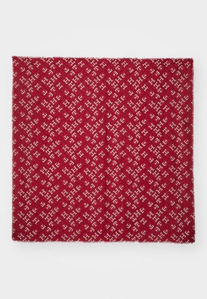 Czerwony prostokątny materiał z powtarzającym się wzorem białych przeplatających się liter "H" na czerwonym tle.