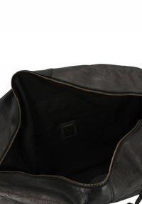 Zwarte leren tote bag met een gladde textuur, ritssluiting en ruime binnenruimte. Beschikt over een subtiele binnenzak en gouden hardware-accenten.