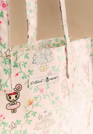 Geantă tote crem cu model floral și mici personaje de desene animate purtând rochii, cu logo-urile Cath Kidston și tokidoki.