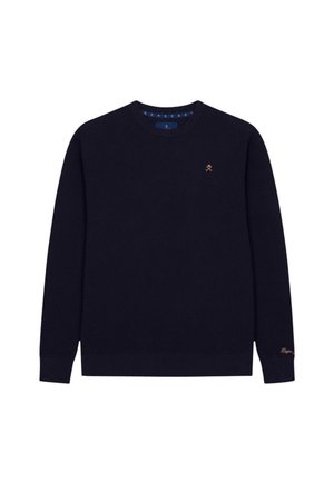 Suéter de punto azul marino con mangas largas, cuello redondo, tejido texturizado, que presenta un pequeño logo dorado en el pecho y un acento dorado en la manga.