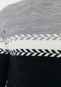 Pull en maille texturée gris, noir et blanc. Présente des motifs ondulés et en chevrons, avec un col côtelé et des textures de points variées.
