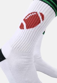 Calcetines deportivos blancos con un gráfico de fútbol americano en rojo, con detalles en negro y verde, textura acanalada y zona de puntera reforzada.