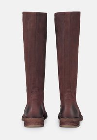 Bottes hautes en cuir bordeaux avec une texture lisse, des détails de couture subtils et un talon en bois empilé. Dos plat, sans accessoires métalliques.